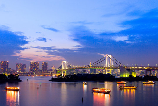 sunset twilight of tokyo skyline, with cityscape and Rainbow Bridge at Odaiba Seaside Park, Odiaba, Tokyo, Japan