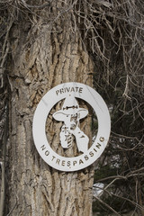No trespassing sign with cowboy with gun