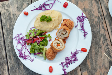 Baked chicken rolls with vegetable salad and mashed potato