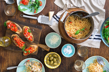 Italian dinner table with pasta, appetizers and white wine