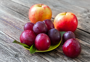 Ripe plums, nectarines and apples on a wooden table
