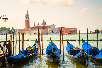 Obraz na płótnie Canvas Venice with romantic and famous gondolas moored on grand Canal by San Marco square. San Giorgio Maggiore church in the background.