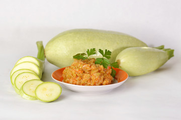 Zucchini squash on the plate and fresh zucchini.