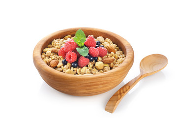 Muesli with nuts and fresh berries in a wooden bowl isolated on white background.