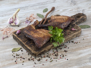 Smoked chicken legs on wooden board. 