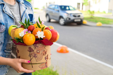 woman received a new original unusual fruit bouquet, outdoors. Celebrating holidays and happiness concept
