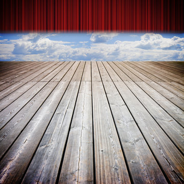Open theater red curtains and wooden floor against a cloudy sky - concep timage