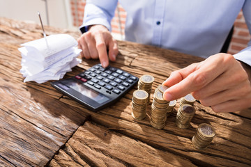 Person Counting Coins Using Calculator
