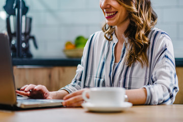  Young woman drinking coffee and working at home