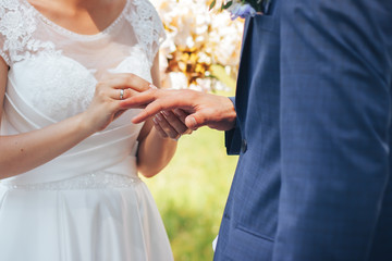 Groom with the bride putting their rings to each other