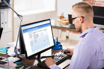 Businessman Doing Online Banking In Office