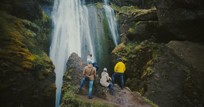 Aerial view of the group of tourist resting on the top of mountain and looking on the Gljufrabui waterfall in Iceland.