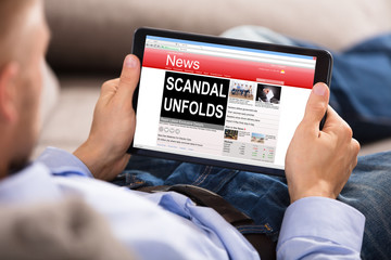 Man Reading Unfolds Scandal News On Digital Tablet - obrazy, fototapety, plakaty