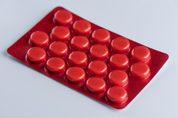 Tablets in a red blister on a white background