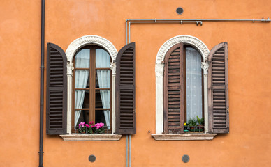 Fototapeta na wymiar Old windows with wooden shutters and curtain in Italy
