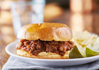 sloppy joe meal with potato chips and pickles
