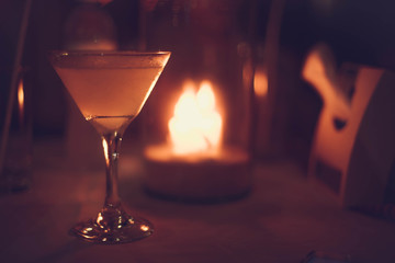Margarita iced cocktail in martini glasses in front of the night bokeh lights on blurred candle background