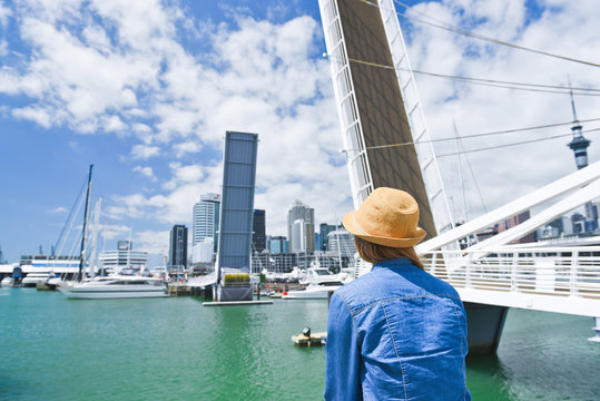 Young traveler woman in hat looking at opening Bridge in Auckland, New Zealand. City life