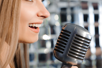 beautiful woman singing on the stage next to the microphone