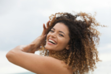 Out of focus portrait of happy woman laughing in summertime