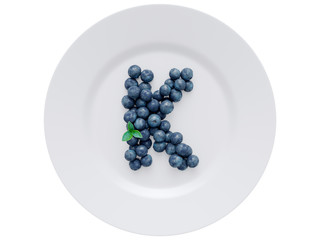 Blueberry font isolated on white ceramic dish. Letter K