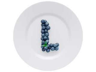Blueberry font isolated on white ceramic dish. Letter L