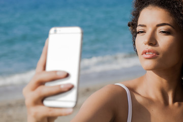 Young woman portrait taking selfie at the beach