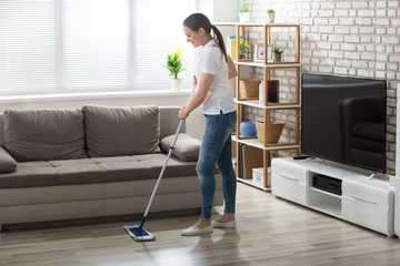Young Woman Cleaning The Hardwood Floor