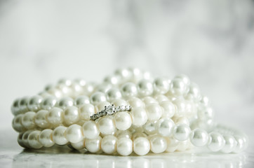 Silver ring with pearls on marble table