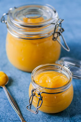 Lemon Curd in Jars over Blue Background
