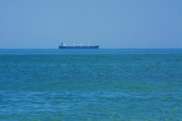 Beautiful seascape. Ship on the horizon on a background of blue sky