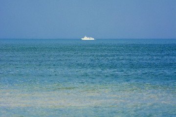 Beautiful seascape. Ship on the horizon on a background of blue sky
