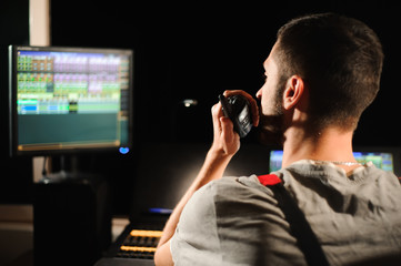 A lighting engineer works with lights technicians control on the concert show. Professional light...