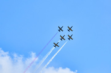 Sport planes aerobatic team vapour trails in blue sky. Plane white vapour trails tracks background. Plane aerobatic maneuver stunt. Stunt planes aerobatic team vapor trails.