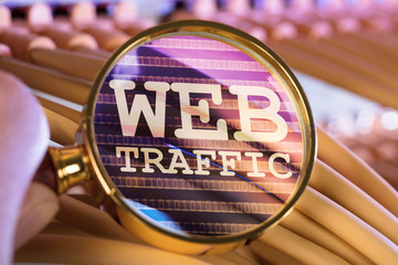 Hand Analyzing Web Traffic Through Magnifying Glass Over Cables