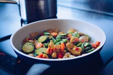Fried chicken with vegetables on the pan in the kitchen