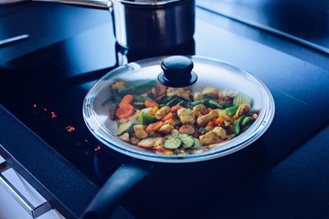 Fried chicken with vegetables on the pan in the kitchen