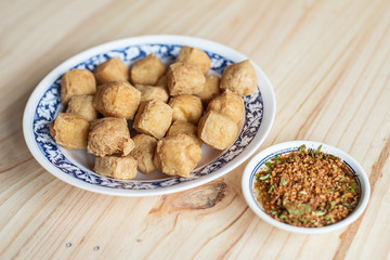 Fried tofu by soybean and Suace with syrup, peanut and chilli Thai food. Food on the wood background 