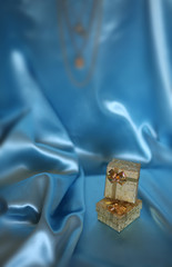Две золотых коробки с подарком внутри на голубом фоне