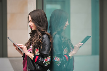 Youth and technology. Attractive young woman using tablet computer outdoors.