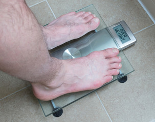 Man's feet on weight scale - Overweight