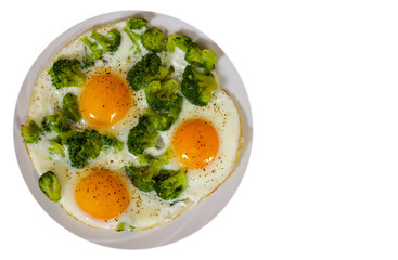 Fried eggs with broccoli in plate. top view. isolated on white