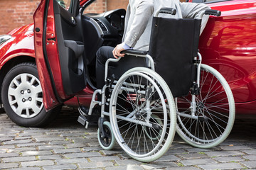 Man Sitting In Car Folding His Wheelchair