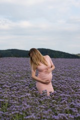 pregnant lady in pink dress on a field