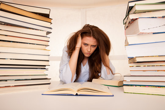 attractive young woman student undre stress while studiing for exames