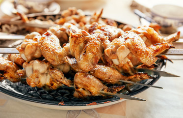 Rosy, fresh roasted on an open fire chicken wings for a family holiday. Selective focus. Summer day.