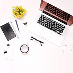 Workspace laptop keyboard mobile phone coffee glasses and flowers