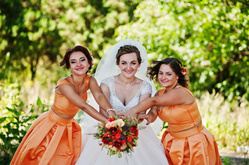 Naklejka premium Happy bride having fun with her cool fun bridesmaids in the park on a wedding day.