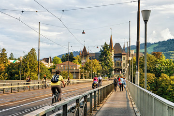 Man riding bicycle and other people on Kirchenfeld bridge Bern