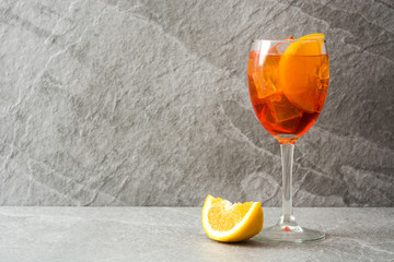 Aperol spritz cocktail in glass on gray stone  